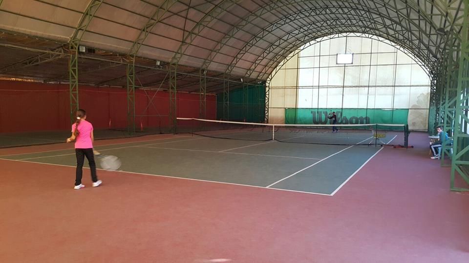 Kapalı kortta forehand çalışan genç sporcu
